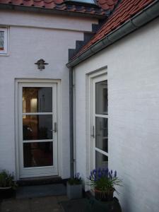 ThemNatursti Silkeborg Bed & Breakfast的白色的房子,有门和一些花