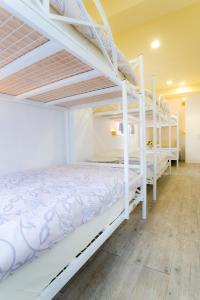 花莲市花莲鸟窝青年旅舍的一间卧室设有两张双层床,铺有木地板。