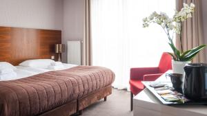 科希切日纳巴组尼酒店&Spa的酒店客房,配有一张床和一张红色椅子