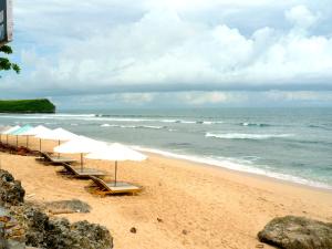乌鲁瓦图The Rishi Villa Balangan的海滩上一排与海洋相伴的遮阳伞
