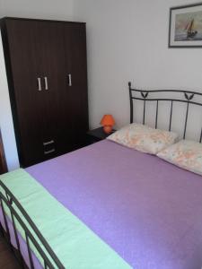 大德尔韦尼克Apartments Niki - 5m from the sea的一间卧室配有紫色的床和黑色橱柜