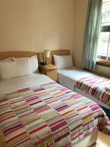 伦敦Seven Dials Hotel的一间卧室设有两张床和窗户。