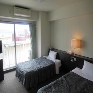 大分Tsurusaki Hotel的酒店客房设有两张床和窗户。