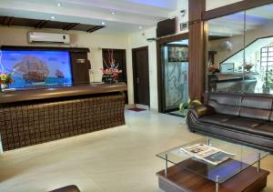 迪布鲁加尔Hotel Raj Palace的带沙发和平面电视的客厅