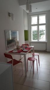 波兹南Apartament w Starej Kamienicy的厨房配有白色的桌椅、桌子和窗户。