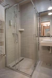 霍莫罗德浴场Homorod Hotel的浴室里设有玻璃门淋浴