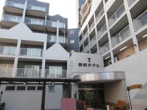 大分Tsurusaki Hotel的建筑的侧面有标志