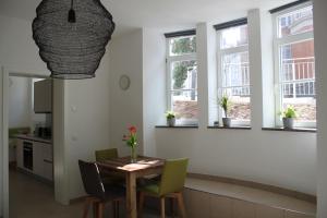 维尔茨堡Stadtvilla Würzburg的一间带桌椅和窗户的用餐室