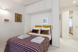 波尔图福尔摩沙公寓的白色卧室配有一张大床和毛巾
