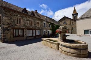 Le BéageMaison VERNET - Hôtel Beauséjour的一座石头建筑,前面有一个喷泉