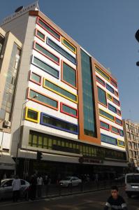 阿达纳森巴亚克市酒店的城市街道上一座高大的建筑,窗户色彩缤纷