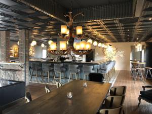 比尔顿Sideways Inn的一间带桌椅和吊灯的餐厅