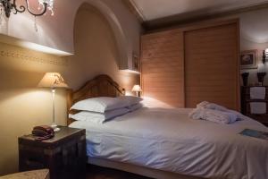 卡尔派尼西翁Anerada inn Suites & Villa - Pet Friendly的卧室配有一张带白色床单和枕头的大床。