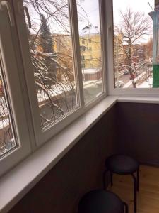 切尔尼戈夫Двухкімнатна студія的靠窗的座位,设有两张凳子和两个窗户