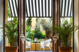 瓦伦西亚帕拉西奥罗哈斯旅馆的配有两把椅子和盆栽的开放式门