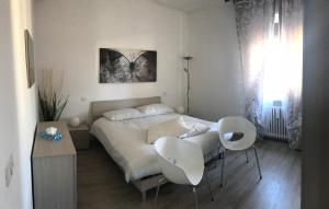 维罗纳Appartamenti Giada的一间卧室配有一张床和两把白色椅子