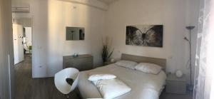 维罗纳Appartamenti Giada的白色卧室配有床和桌子
