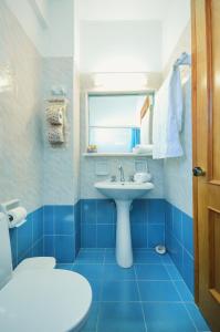 阿里克海滩Skarmoutsos Studios的蓝色的浴室设有水槽和窗户