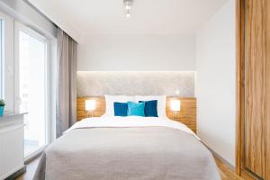 卡托维兹ActivPark Apartments的一间卧室配有一张带蓝色枕头的大床