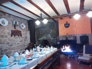 SajazarraCasa Bodega Vacacional的一间带长桌和壁炉的用餐室