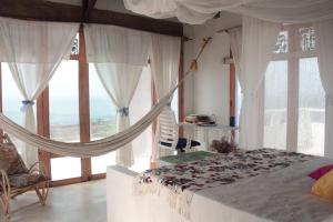 圣维罗尼卡Frente al Mar的一间卧室设有吊床和大窗户