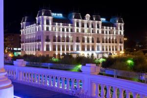 桑坦德萨尔大酒店的一座白色的大建筑,晚上有灯