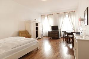 博尔扎诺Residence Fink Central Apartments的一间卧室配有一张床、一张桌子和一张桌子