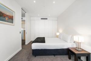 吉朗埃吉沃特207公寓的一间卧室配有一张床和一张带台灯的桌子