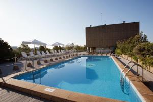 萨拉戈萨帕拉福克斯酒店的一座带椅子的大型游泳池和一座建筑