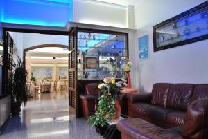 切萨雷奥港地中海酒店的客厅配有真皮沙发和桌子