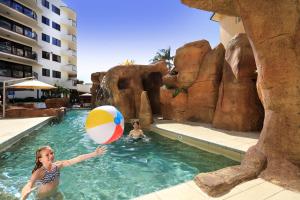 穆卢拉巴加勒比度假酒店的年轻女孩在游泳池玩沙滩球