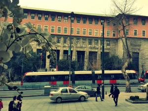 伊斯坦布尔肯特酒店的街道,在建筑物前有汽车和巴士的城市街道