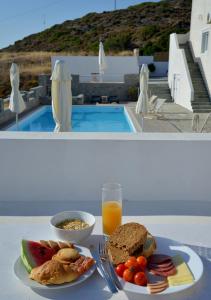 阿波罗尼亚Glaronisia Hotel的一张桌子,上面放着一盘食物和一杯橙汁