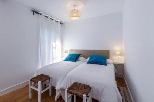 宏达瑞比亚Apartamento Carlos V的白色客房的两张床,配有蓝色枕头