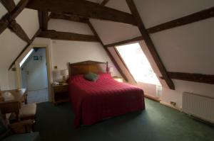 诺里奇Stower Grange Hotel的阁楼卧室配有红色床