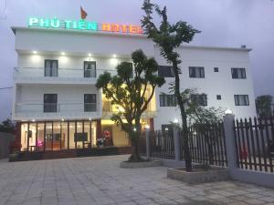 洞海Phu Tien Hotel的白色的建筑,上面有标志