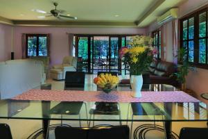 蔻立Coral Beach Pool Villa Khao Lak - SHA Extra Plus的客厅配有带鲜花的玻璃桌