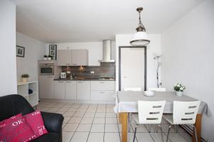 诺尔贝克Vroeleneind的白色的厨房配有桌子和椅子