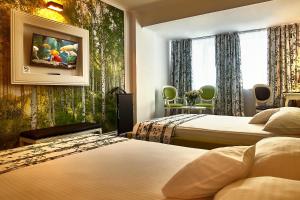 阿拉德阿拉德大陆酒店的酒店客房设有两张床,墙上挂有绘画作品