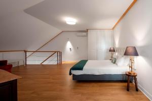 里斯本帕拉西奥贾梅士 - 里斯本服务式公寓的一间卧室配有一张床,房间设有楼梯