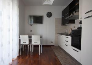 加埃塔Vento di Ponente的厨房配有桌子和两把白色椅子
