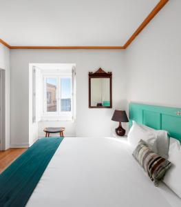 里斯本帕拉西奥贾梅士 - 里斯本服务式公寓的一间卧室设有一张大床和一个窗户。