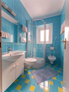 奥蒂塞伊托尼加尼酒店的蓝色瓷砖浴室设有水槽和卫生间