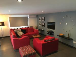 莫莱拉Villa San Antonio的客厅配有红色的沙发和两把椅子