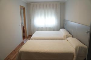 波尔托马林Pension Perez的一间卧室设有两张床和窗户。