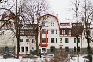 里加New, modern apartment near Riga center的一座白色的大建筑,前面有汽车停放
