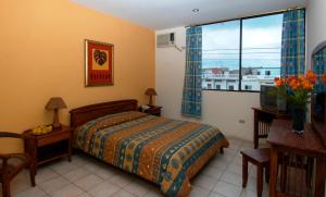 马查拉Hostal Solar Del Puerto的一间卧室配有一张床、一张书桌和一个窗户。
