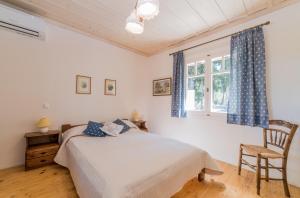 阿克罗蒂Villino Guest House的卧室配有床、椅子和窗户。