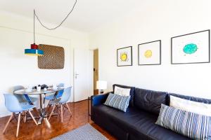 里斯本WHome | Anjos Stylish Apartment #6的客厅配有黑色真皮沙发和桌子