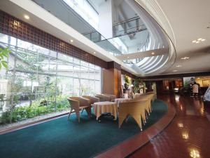 熊本Ark Hotel Kumamotojo Mae -ROUTE INN HOTELS-的大楼内带桌椅的用餐室